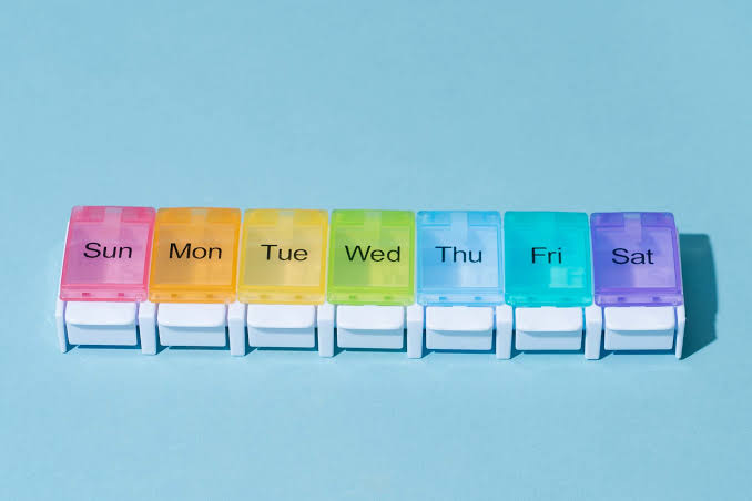 Pilulier de sept casiers colorés, un par jour de la semaine, de dimanche à samedi